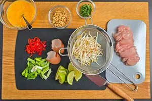 Hähnchenbrust und weitere Zutaten für Pad Thai vorbereiten