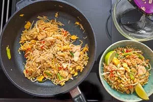 Sojasprossen und restliche Sauce in die Pad-Thai-Pfanne geben
