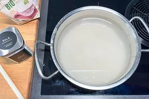 Gewaschenen Reis und Salz in einen Kochtopf geben
