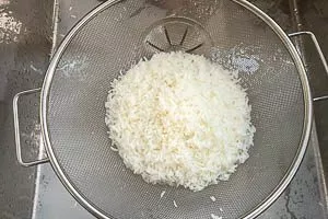 Reis in einem Sieb abgießen und abtropfen