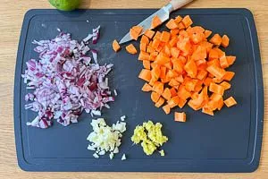 Zwiebeln, Möhren, Knoblauch und Ingwer schneiden