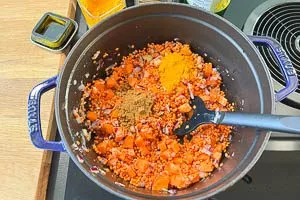 Zutaten für rote Linsensuppe im Topf vermengen