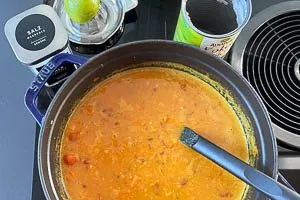 Kokosmilch zur roten Linsensuppe hinzugeben