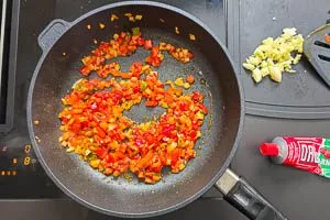 Tomatenmark in die Pfanne geben