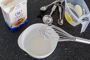 Zuckerguss mit Puderzucker und Wasser anrühren