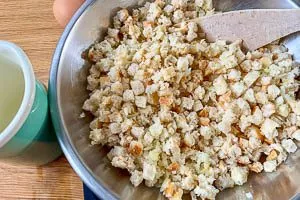 Milch-Mischung zu den Br&ouml;tchenw&uuml;rfeln geben und quellen lassen.