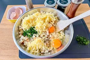 Eier, Bergk&auml;se, Petersilie und Gew&uuml;rze hinzugeben.