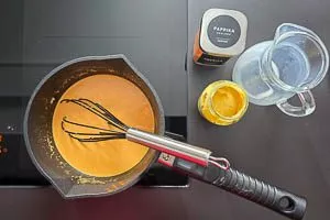 Paprikapulver, Senf und Milch in die Mehlschwitze geben.