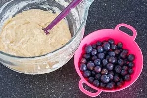 Zartbitterschokolade oder Beeren für Blaubeer-Muffins unterrühren