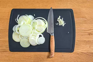 Zwiebeln in Ringe schneiden und Knoblauchzehe würfeln oder pressen.