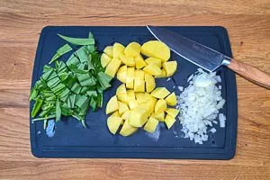 Kartoffeln, Bärlauch und Zwiebeln vorbereiten und klein schnippeln.