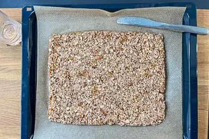 Müsli-Masse auf dem Backblech verteilen und festdrücken