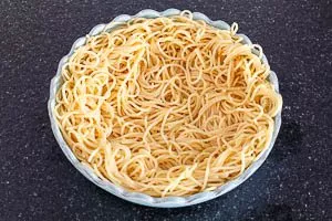 Spaghetti zu einem Nest in der Auflaufform formen.