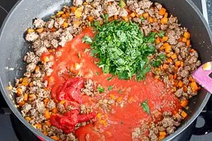 Passierte Tomaten, Tomatenmark und Petersilie hinzugeben, nochmal abschmecken.