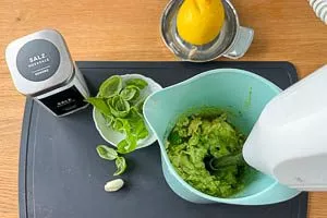Mit Basilikum, Salz und Zitrone wird die Avocado püriert.