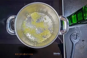 Zwiebeln und Knoblauch in einem Topf in Pflanzenöl andünsten