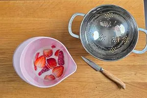 Erdbeeren mit Milch in den Rührbecher geben.