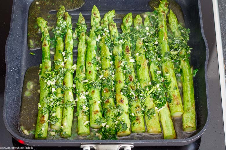Grünspargel in Öl mit Kräutern in der Pfanne gebraten