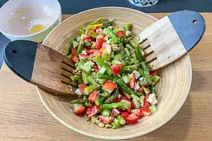 Dressing zu den Spargelsalat-Zutaten in die Schüssel geben und vermengen