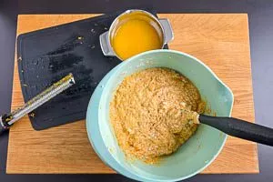 Karottenraspeln und Orangenschale und -saft hinzugeben.