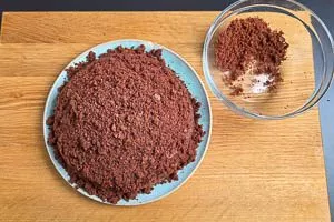 Krümel aus dem Kuchenteig auf der Sahnekuppel verteilen