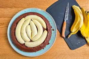 Kuchenboden mit halbierten Bananen belegen