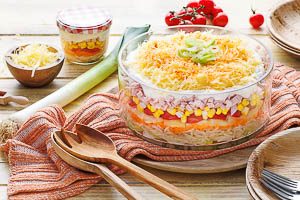 Schichtsalat in einer Glasschüssel servieren