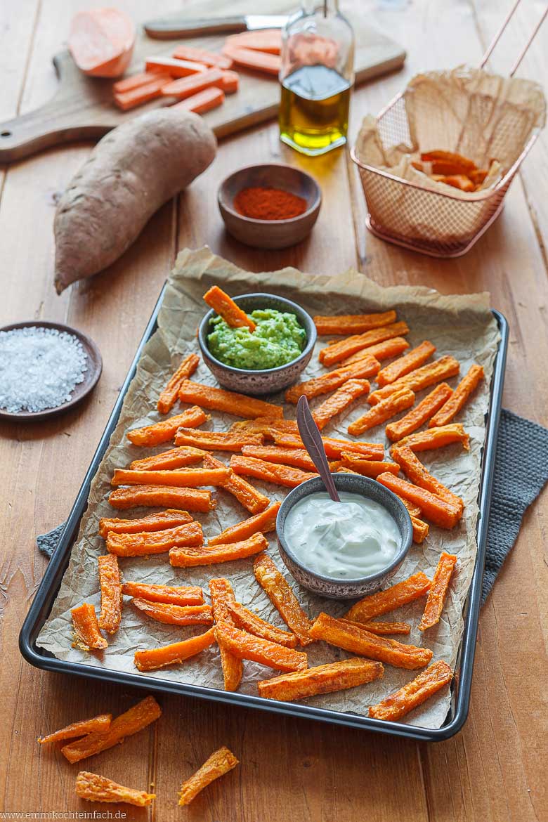 Pommes frites aus S&uuml;&szlig;kartoffeln auf einem Blech mit Dips serviert