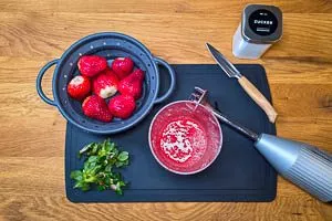 Erdbeeren waschen, einen Teil zerkleinern, den anderen in Stücke schneiden
