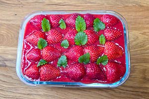 Mit den restlichen Erdbeeren und Zitronenmelisse garnieren