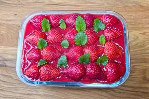Mit den restlichen Erdbeeren und Zitronenmelisse garnieren