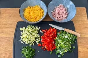 Gemüse, Cheddar und Schinken klein schnippeln.