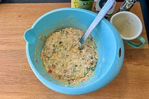 Gemüse, Cheddar und Schinken zum Teig geben.