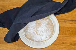 Ein Tuch über den Teig legen und ihn erneut gehen lassen