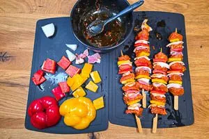 Fleisch und Gemüse abwechselnd auf die Schaschlikspieße stecken