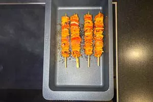 Fleischspieße in einem Bräter braten