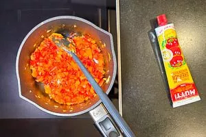 Tomatenmark in den Topf zugeben und anrösten.