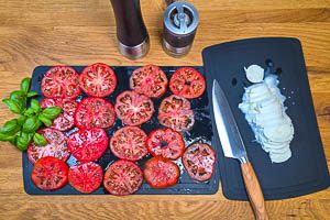 Basilikum waschen und Mozzarella in gleich viele Scheiben wie die Tomaten schneiden.