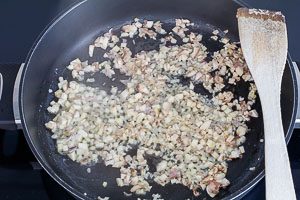 Anbraten von Schalotten und Knoblauch in der Pfanne.
