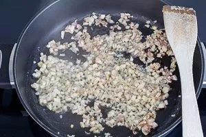 Anbraten von Schalotten und Knoblauch in der Pfanne.