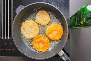 Panierte Kohlrabischeiben beidseitig in der Pfanne anbraten