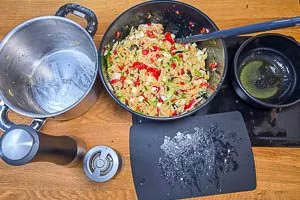 Gemüse und gekochte Kritharaki-Nudeln vermengen und Feta klein schneiden und dazu geben.