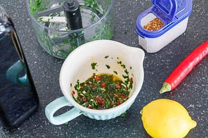 Olivenöl, Zitronensaft, Chiliflocken, fein gewürfelte Knoblauchzehen, gewürfelte Chilischote und Petersilie zu einer Soße vermengen.