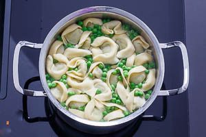 Tortellini und Erbsen in Salzwasser kochen