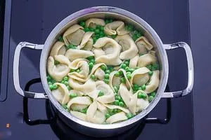 Tortellini und Erbsen in Salzwasser kochen
