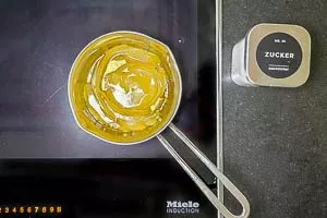 Wasser, Zucker und die Zitronenschalen in einem kleinen Topf mit Wasser erhitzen und abkühlen lassen.