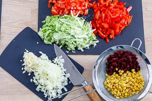 Schneide das frische Gemüse in Streifen und Würfel und lasse das Gemüse aus den Dosen abtropfen.