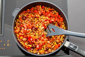 Gib die Tomatenwürfel dazu und schmeck die Füllung ab.
