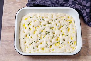 Focaccia-Teig abgedeckt in der Auflaufform ruhen lassen