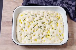 Focaccia-Teig abgedeckt in der Auflaufform ruhen lassen